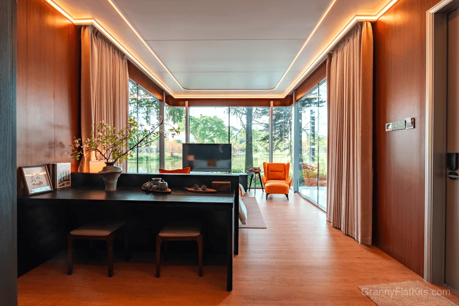 Interior living and workspace area with wood paneling, LED lighting, and floor-to-ceiling windows